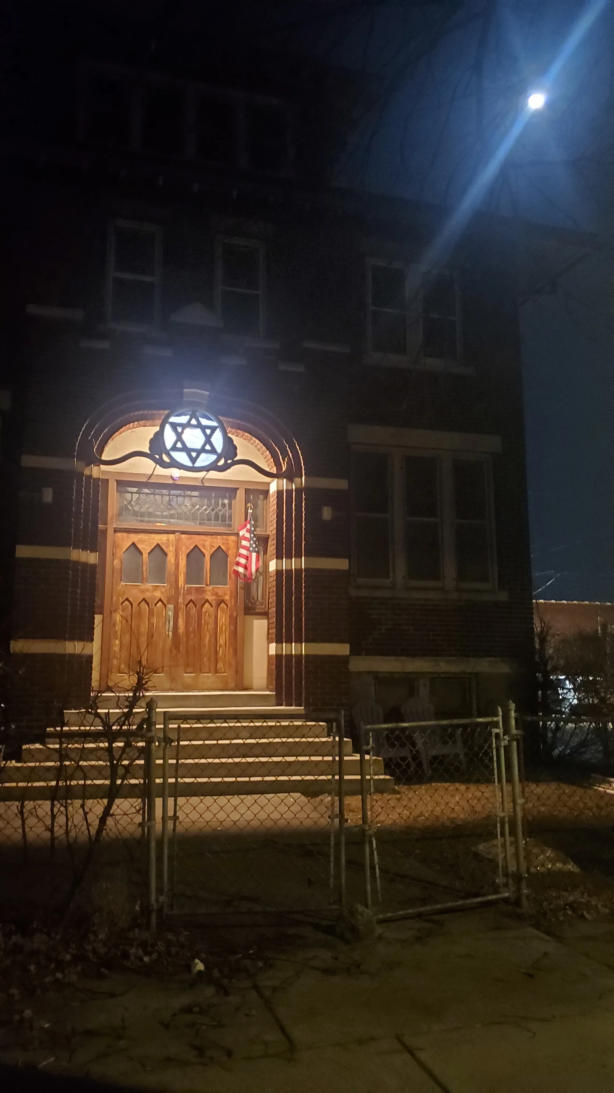 The lit Star of David window above the entrance at night