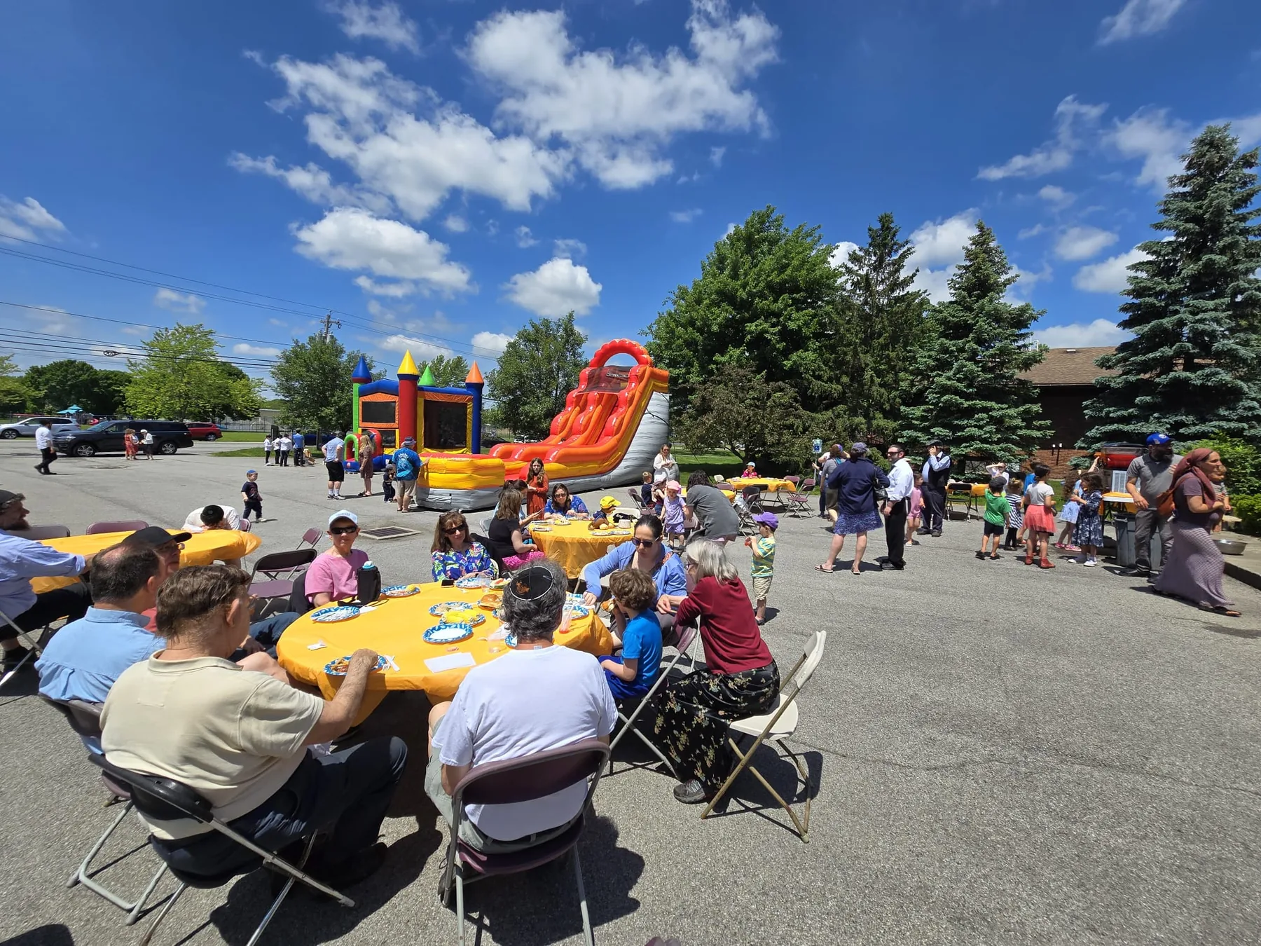 Families seated at tables outdoors for a barbecue