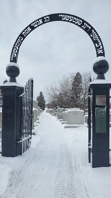 The arched Hebrew gateway of the Anshei Emes Cemetery in winter